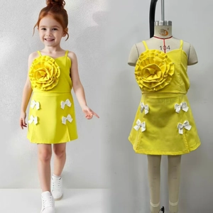 Detail of summer yellow girls' set featuring 3D floral top and bow-decorated mini skirt