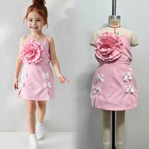 Detailed view of pink two-piece girls' outfit with a large 3D flower and bow skirt