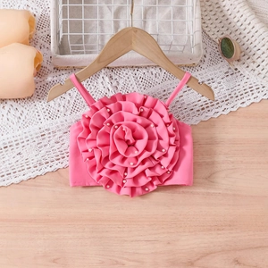 Détail d'un camisole rose pour fille avec grande applique florale 3D et perles blanches