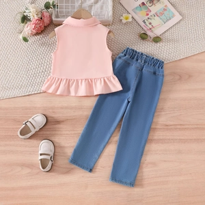 Détails à plat d'un ensemble fille avec haut rose à volants et pantalon en jean bleu