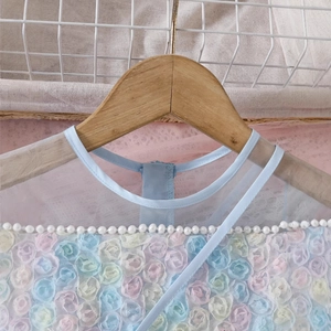 Detail of sequin rainbow girl dress featuring 3D mesh flowers and white pearl neckline decor