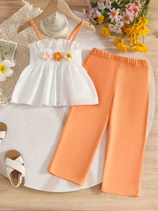 Girls summer outfit with floral white tank top and orange wide-leg trousers set