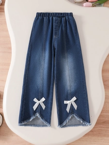 Girls dark blue denim pants with bow detail and fringed hem on wooden background