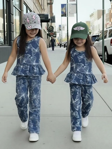 Girls denim set with sleeveless peplum top and floral print jeans on urban street