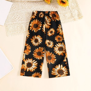 Détail à plat d'un pantalon large noir pour filles avec imprimés de tournesols