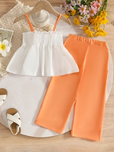 Girls summer two-piece outfit with white floral ruffled top and orange wide-leg trousers