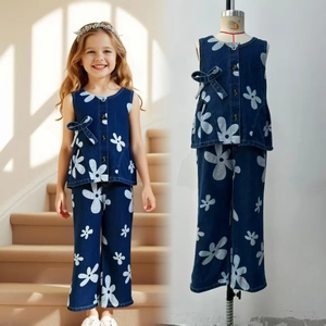 Détail de l'ensemble en jean pour filles avec imprimés fleurs blanches et nœud bleu