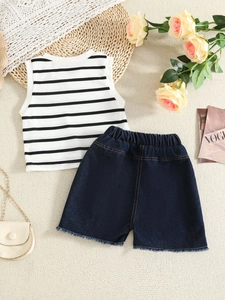 Girls summer set with black striped sleeveless top and frayed denim shorts on a woven background