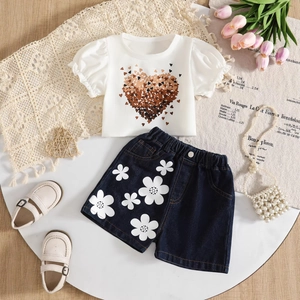 Detail of girls heart print puff sleeve top and floral denim shorts summer outfit set