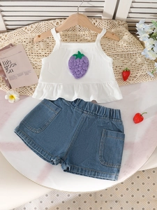 Tenue d'été fille avec débardeur fraise blanc et short en jean sur fond de marbre
