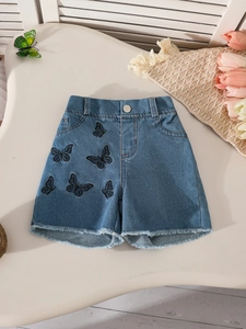 Girls denim shorts featuring black butterfly embroidery and frayed hem on a cream background
