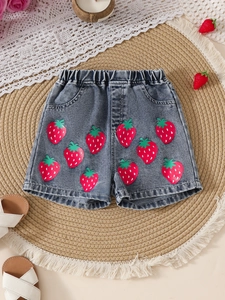 Flat lay of girl's blue denim shorts with strawberry prints and elastic high waist