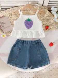 Ensemble d'été fille avec caraco fraise blanc et short en jean bleu sur fond en marbre