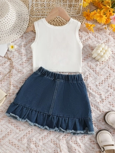 Detail of girls' summer set with white sleeveless top and denim skirt with ruffled hem