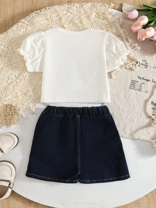 Flat lay of girls' white puff sleeve top and denim shorts with elegant props