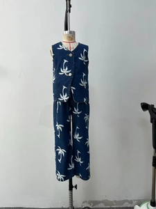 Detail of dark blue denim sleeveless vest and trousers with white coconut tree pattern