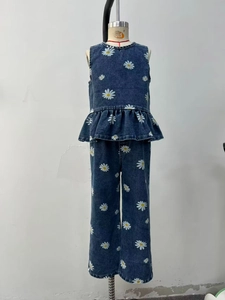 Detail of girls' blue denim two-piece set with white daisy prints and ruffled hem