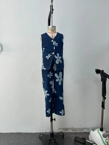 Detailed view of kids denim two-piece set featuring white floral patterns on dark blue fabric