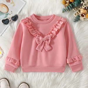 Detail of pink girls' sweatshirt featuring V-shaped ruffles and a sweet bow accent