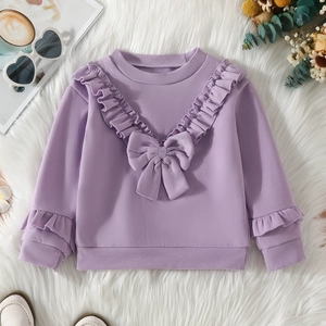 Detailed close-up of girls purple sweatshirt with V-shaped ruffles and a large bow