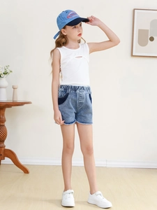 Girls summer outfit with white tank top and light blue denim shorts with frayed hems