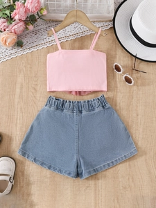 Mädchen Sommer-Set mit rosa Trägertop und blauen Denim-Shorts auf Holzgrund