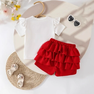 Flat lay of girls' white ruffle sleeve T-shirt and red tiered skirt set with summer accessories
