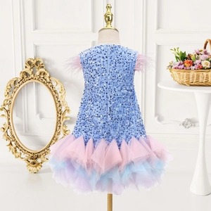 Detail of girls' sequined dress featuring pink feather shoulders and pastel mesh layers