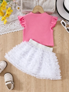Flat lay of pink ribbed ruffle t-shirt and white layered mesh tutu skirt for girls