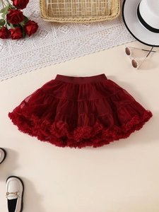 Detailed flat lay of a girls dark red layered tulle tutu skirt with elegant decor