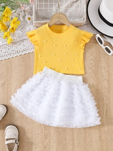 Detail of yellow ribbed knit tee with pearl beads and white layered tulle tutu skirt