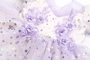 Detail of 3D purple flower embroidery and colorful sequins on a tulle princess dress