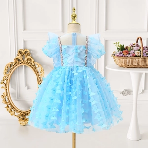 Détail d'une robe de fille bleu clair avec papillons 3D et plusieurs couches de tulle fin