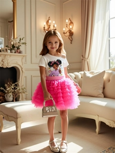 Détail d'un t-shirt blanc à épaules dénudées et jupe en tulle rose pour petites filles