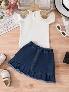 Completo estivo bimba con top bianco a balze e gonna di jeans blu con frange