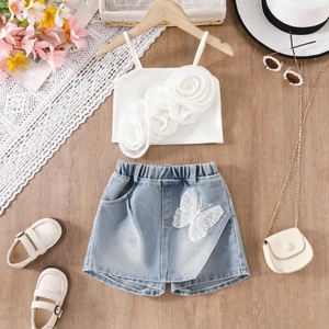 Detail von Mädchen Sommerset mit 3D Blumen-Top und Schmetterling-Jeansrock auf Holzboden