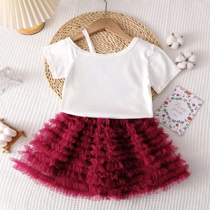 Détail du t-shirt blanc à col asymétrique et ensemble jupe tutu en tulle bordeaux