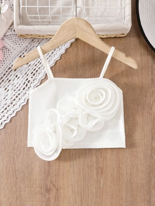 Weißes Mädchen-Trägertop mit großen 3D-Blumenakzenten auf einem Holzkleiderbügel