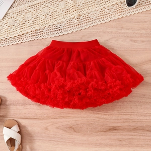 Flat lay of red layered tutu skirt with elastic waistband and fashion accessories