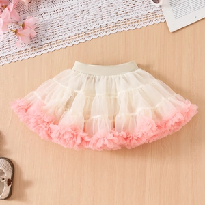 Close-up of baby tutu skirt with layered cream mesh and pink ruffled hem detail