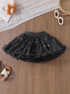 Black girls tutu skirt with silver star prints and elastic waistband on wood floor