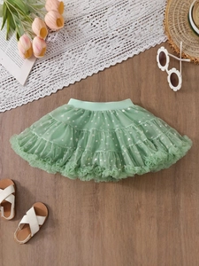 Mint green girls tutu skirt with silver star prints and elastic waistband on wood background