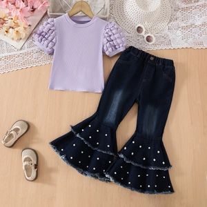 Flat lay of girl's lilac puff sleeve top and pearl-beaded denim flare pants set
