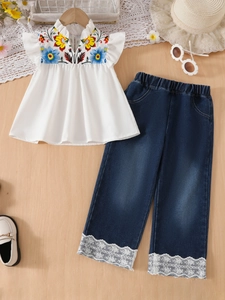 Girls' summer set featuring floral embroidered top and lace hem denim jeans on wood background