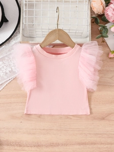 Pink knit short sleeve girl's top with multi-layer mesh ruffles on a wooden hanger