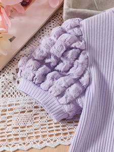 Detail of lavender puff sleeve knit top featuring textured bubble sleeves and ribbed fabric