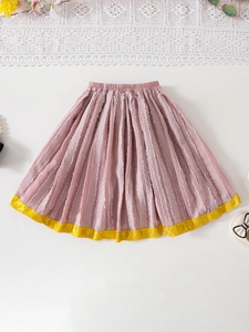 Close-up of pink pleated skirt with bright yellow trim and elastic waistband