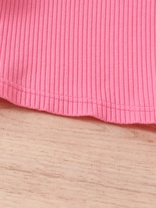 Pink sweet girls' ribbed top with mesh sleeves and ruffle trim on a wooden background