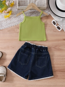 Flachbild von gestricktem Mädchen-Top und Jeans-Shorts mit Spitze auf Holz-Hintergrund