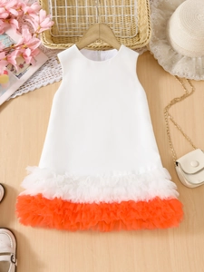 Detailed view of girls sleeveless dress with contrast orange tulle layered hem
